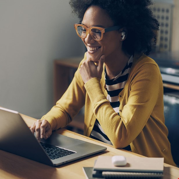 Kvinna leende vid laptop foto Istock