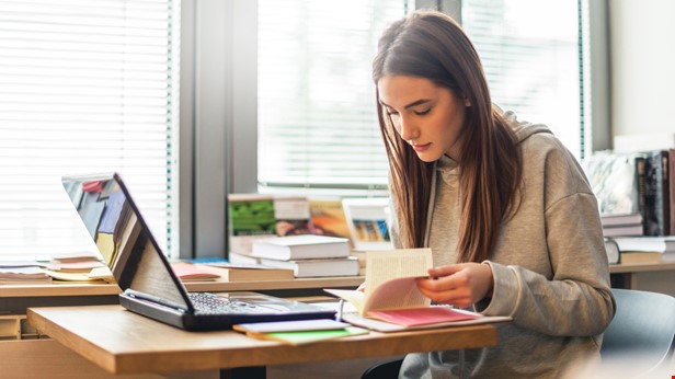 En student bläddrar i läromedel foto Istock